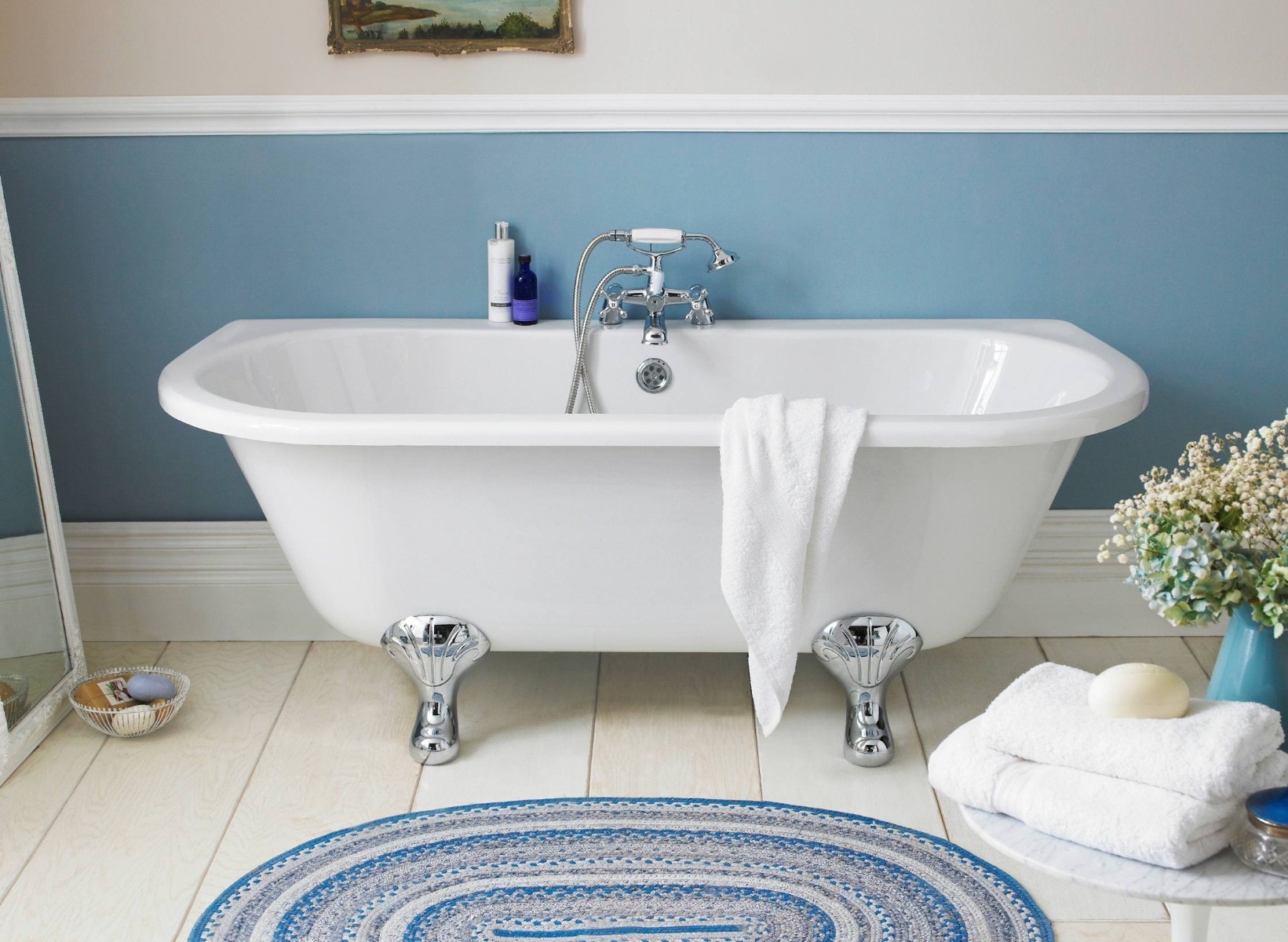 Light blue bathroom with white roll top bath